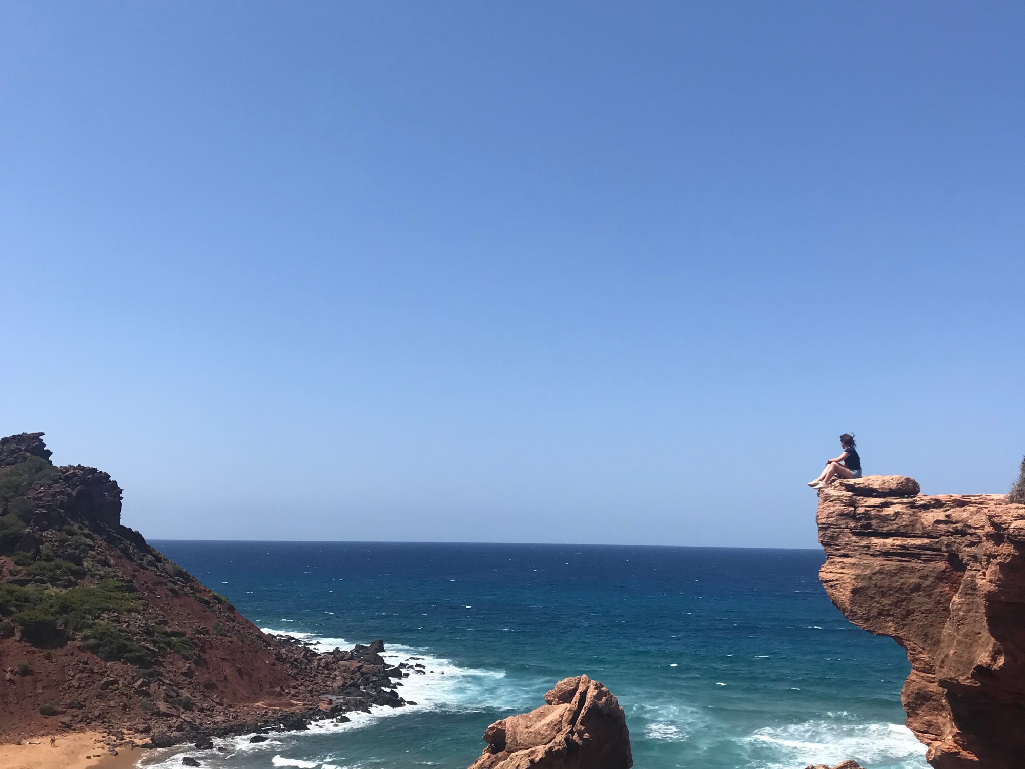 Donna su uno sperone a Cala del Pilar - Minorca, Isole Baleari, Spagna