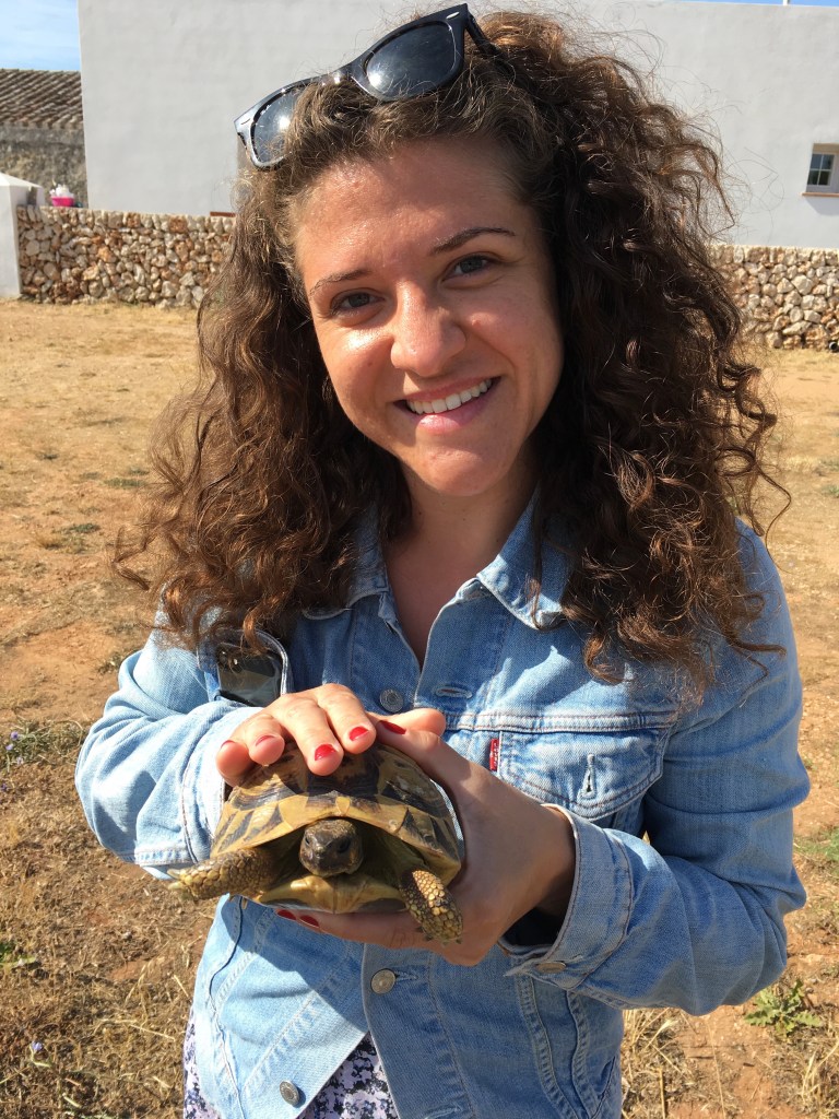 Donna accarezza una tartaruga di terra - Minorca, Isole Baleari, Spagna