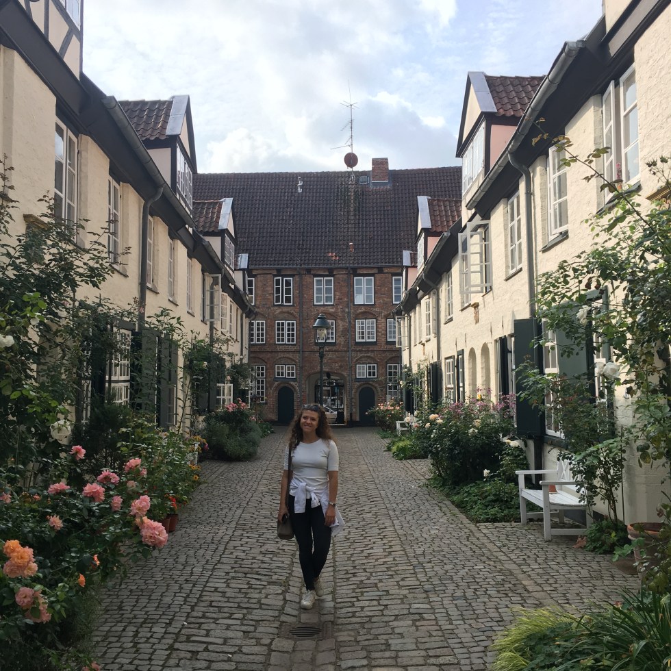 Donna posa nel cortile di Füchtingshof - Lubecca, Schleswig-Holstein, Germania