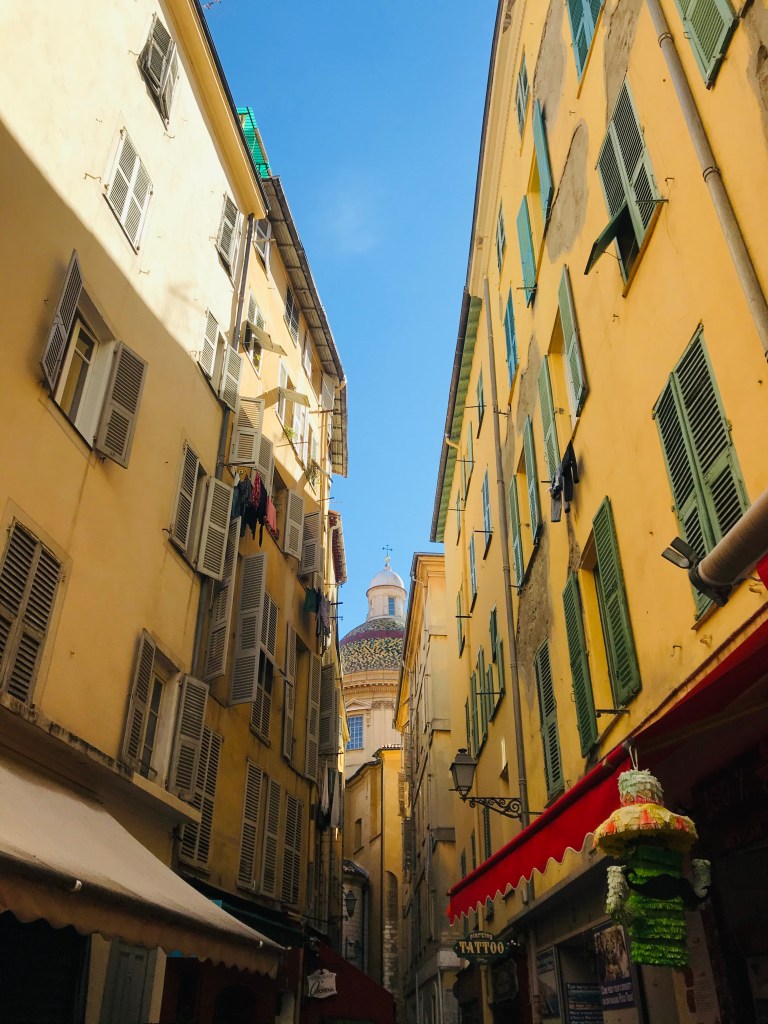 Una viuzza di Nizza Vecchia e, sullo sfondo, la cupola della la Cathédrale Sainte-Réparate de Nice - Nizza, Costa Azzurra, Francia