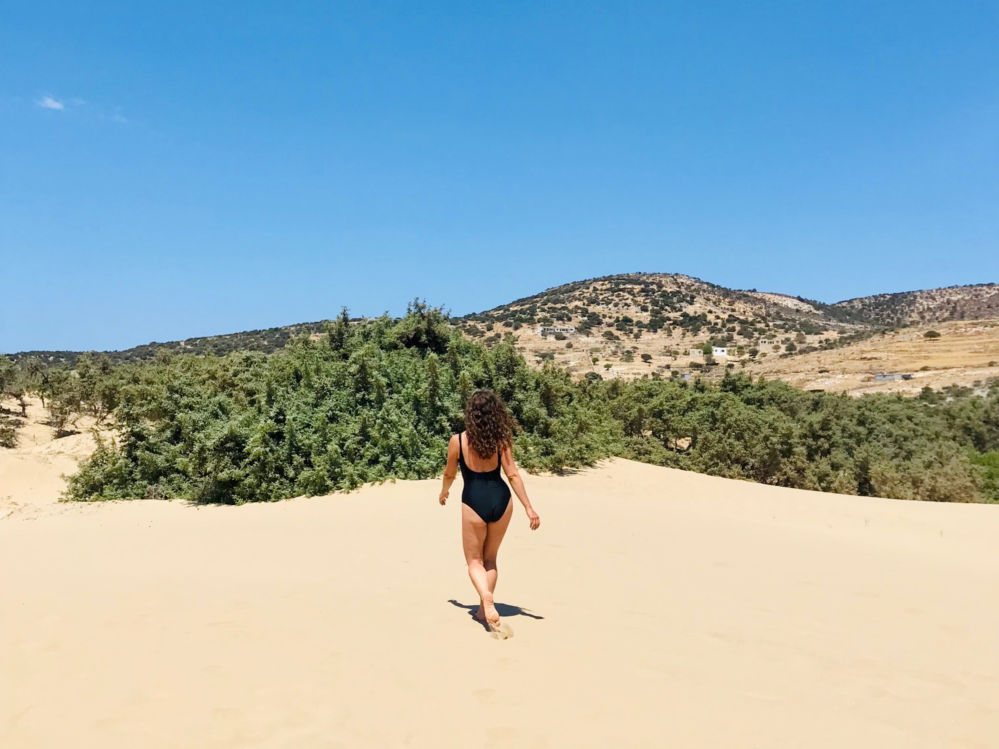 Donna cammina sulle dune della spiaggia di Pyrgaki - Naxos, Isole Cicladi, Grecia