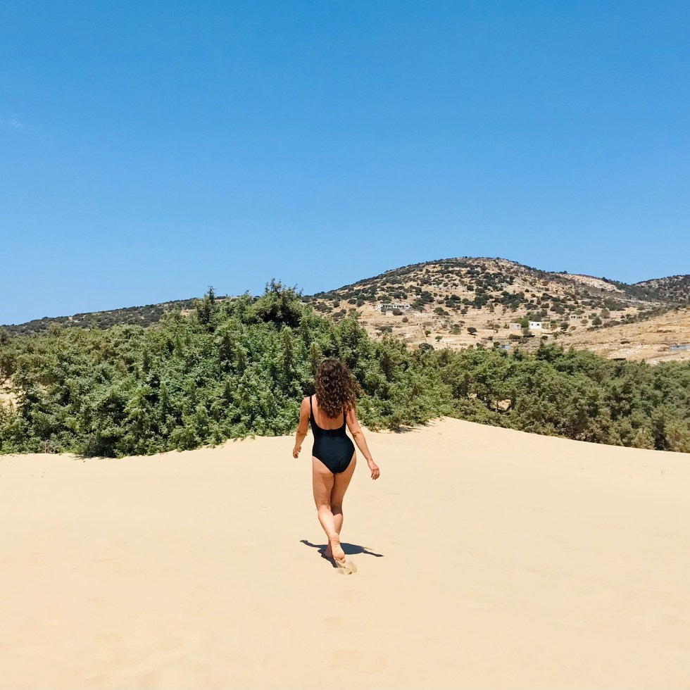 Donna cammina sulle dune della spiaggia di Pyrgaki - Naxos, Isole Cicladi, Grecia