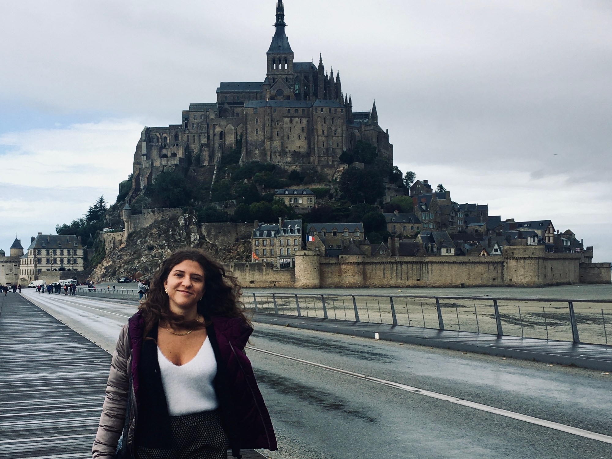 Donna sorridente di fronte all'abbazia di Mont Saint Michel - Normandia, Francia
