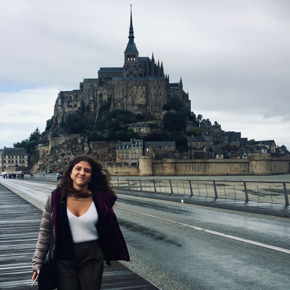 Donna sorridente di fronte all'abbazia di Mont Saint Michel - Normandia, Francia