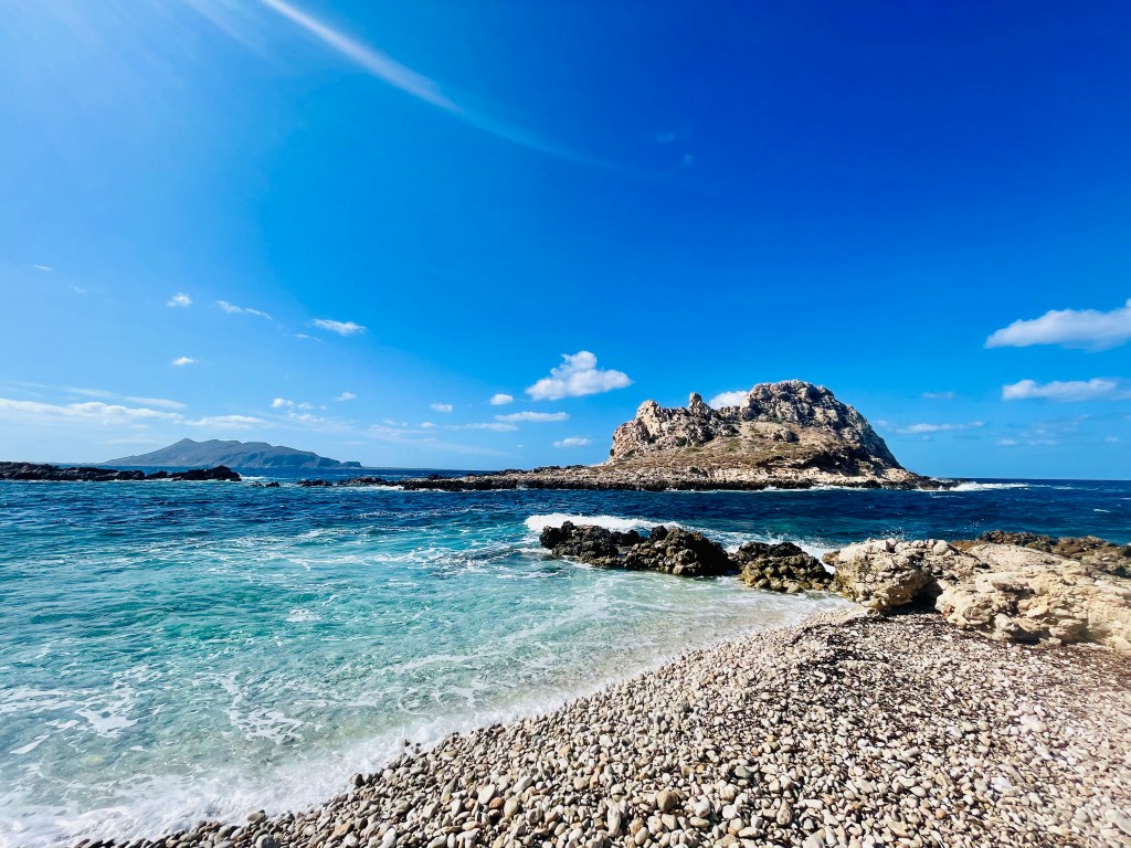 Il faraglione e, sullo sfondo, Favignana a Cala Faraglione - Levanzo, Isole Egadi, Italia