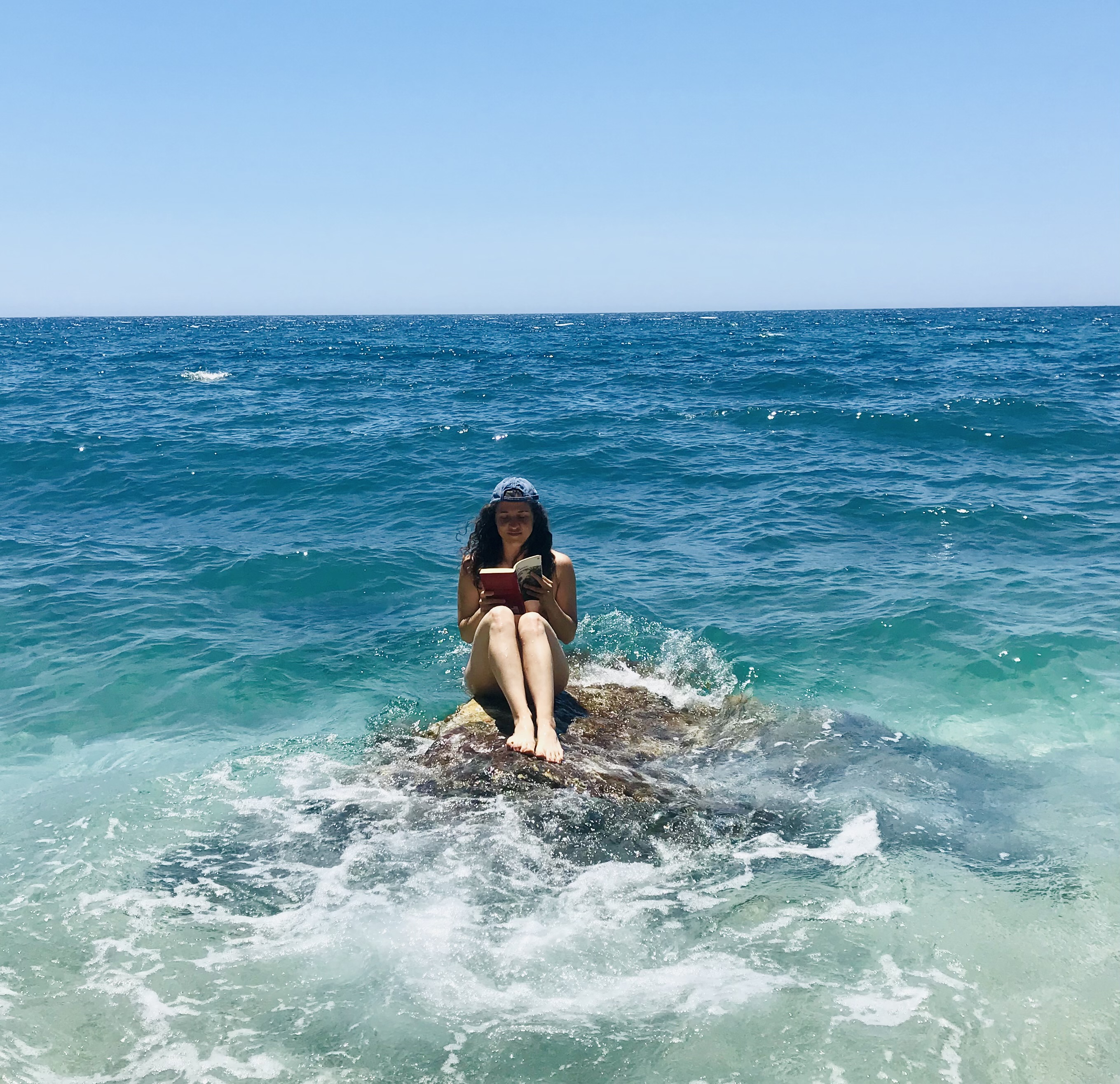 Leggere su uno scoglio alla spiaggia di Paliochori - Milos, Isole Cicladi, Grecia