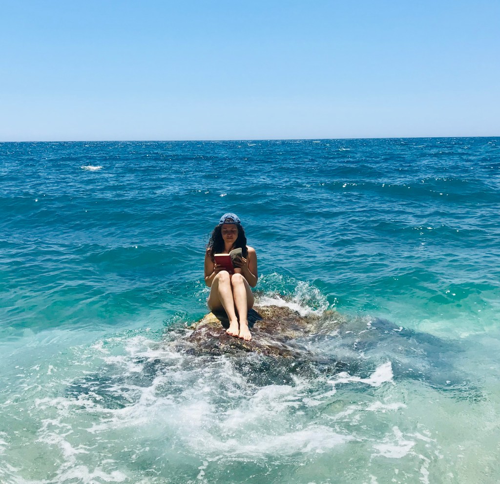 Leggere su uno scoglio alla spiaggia di Paliochori - Milos, Isole Cicladi, Grecia