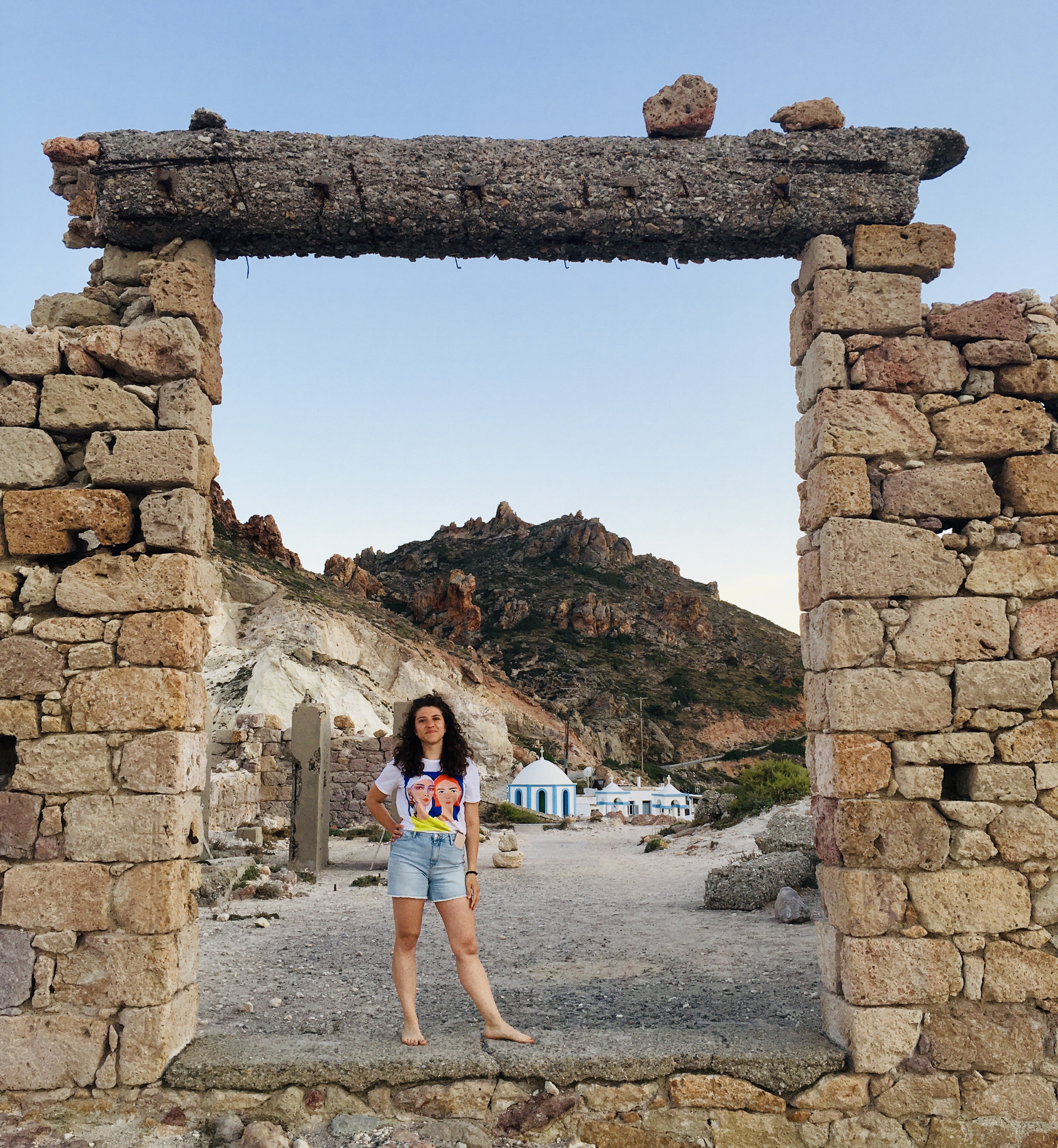 Arco di sassi e sullo sfondo il paesino di Firopotamos - Milos, Isole Cicladi, Grecia