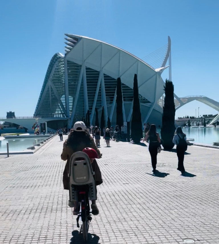 Donna in bicicletta per la Ciudad de las Artes y las Ciencias - Valencia, Spagna