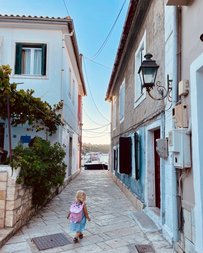 Bimba piccola cammina per le viuzze di Lakka - Paxos, Isole Ioniche, Grecia